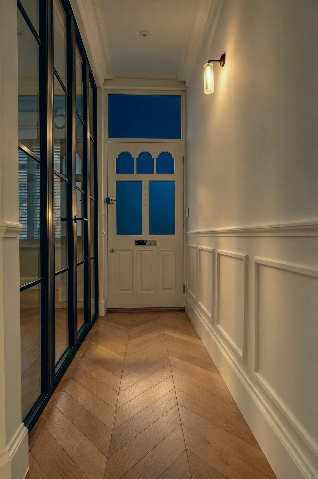 Hallway lined with a black steel glazed screen